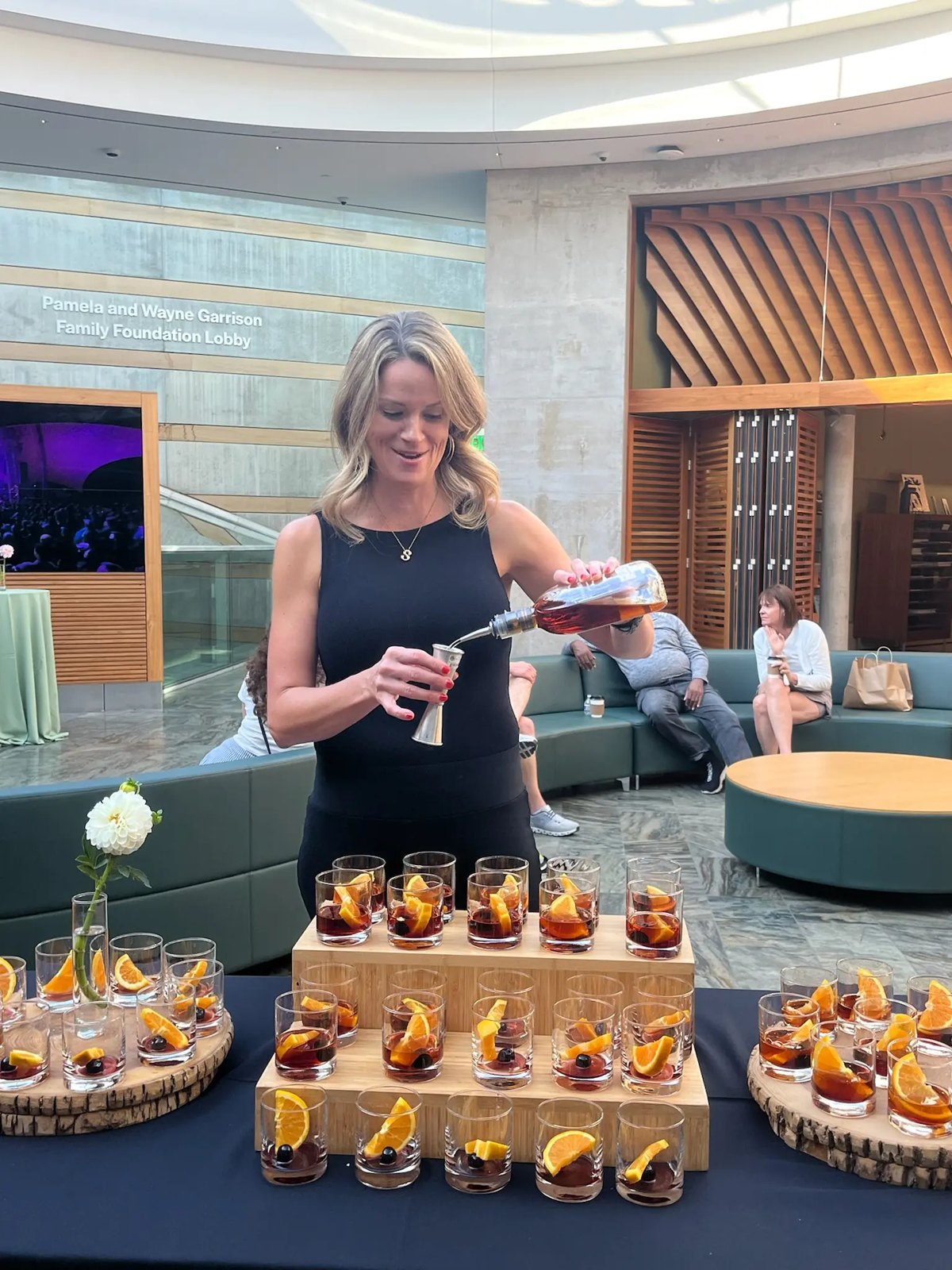 A bartender pouring a tray of old fashioneds at a corporate event