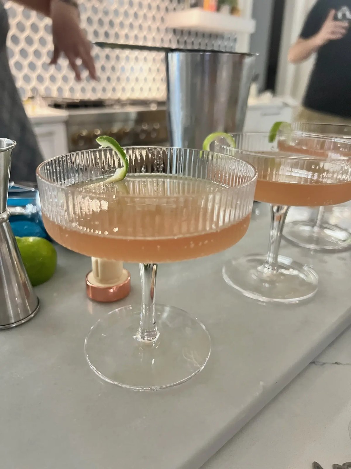 Coupe cocktails with lime on a marble bar
