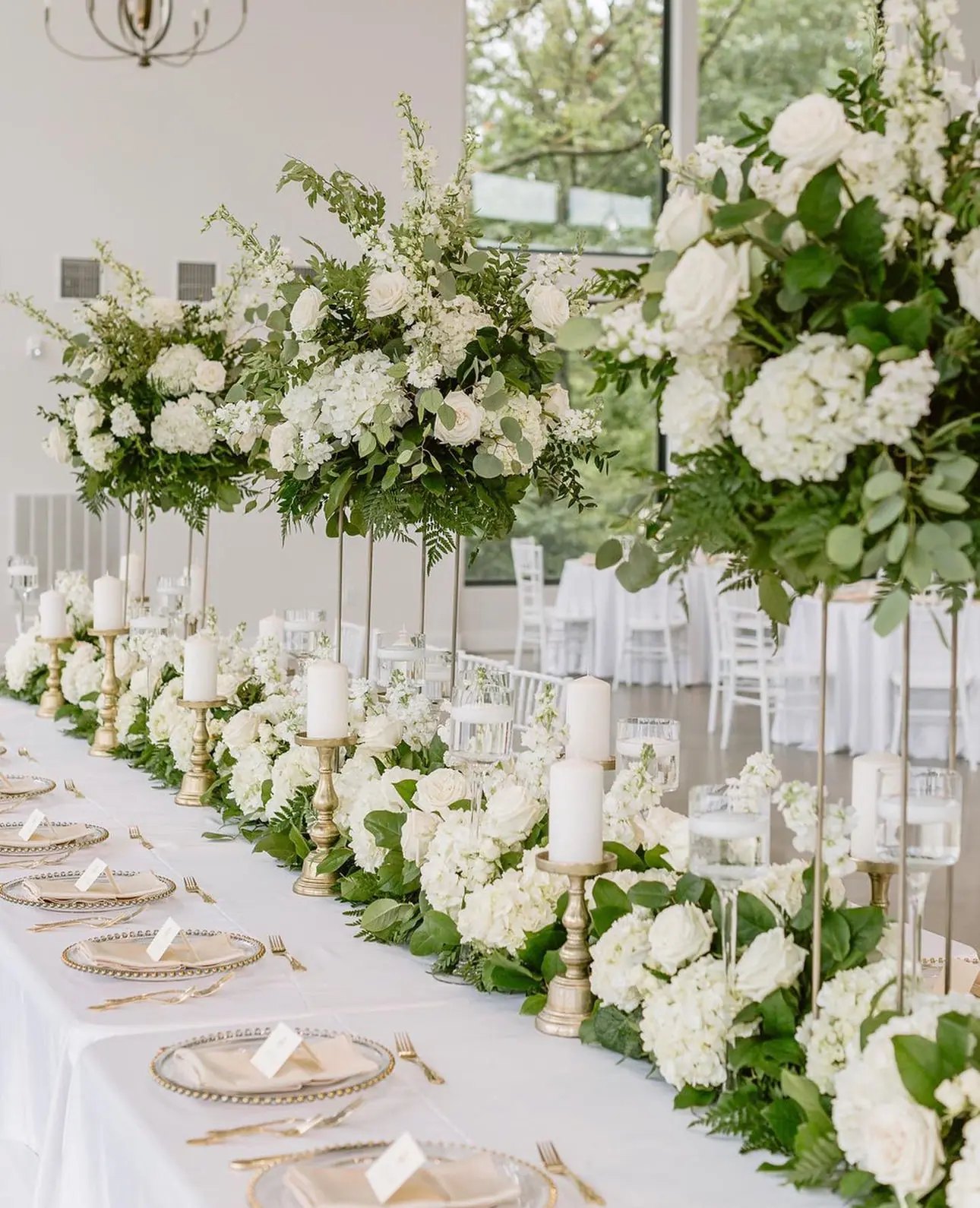 A long wedding table with white florals and candles