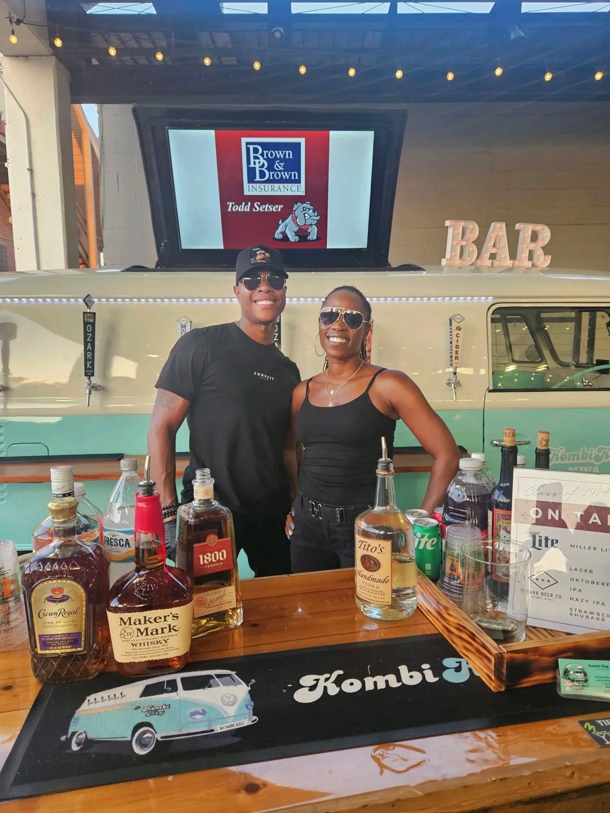 Two bartenders at a vintage Kombi bar at a festival