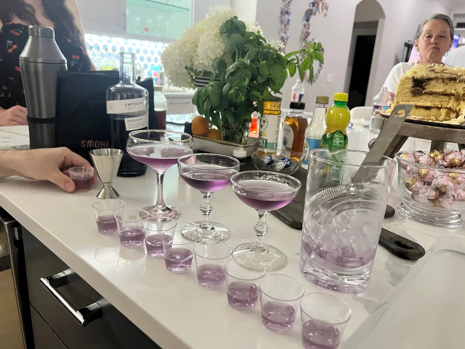 Lavender cocktails in coupe glasses on a kitchen counter